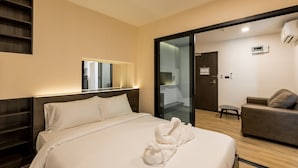 Una habitación de hotel con cama, sofá, una mesita y un espejo.
