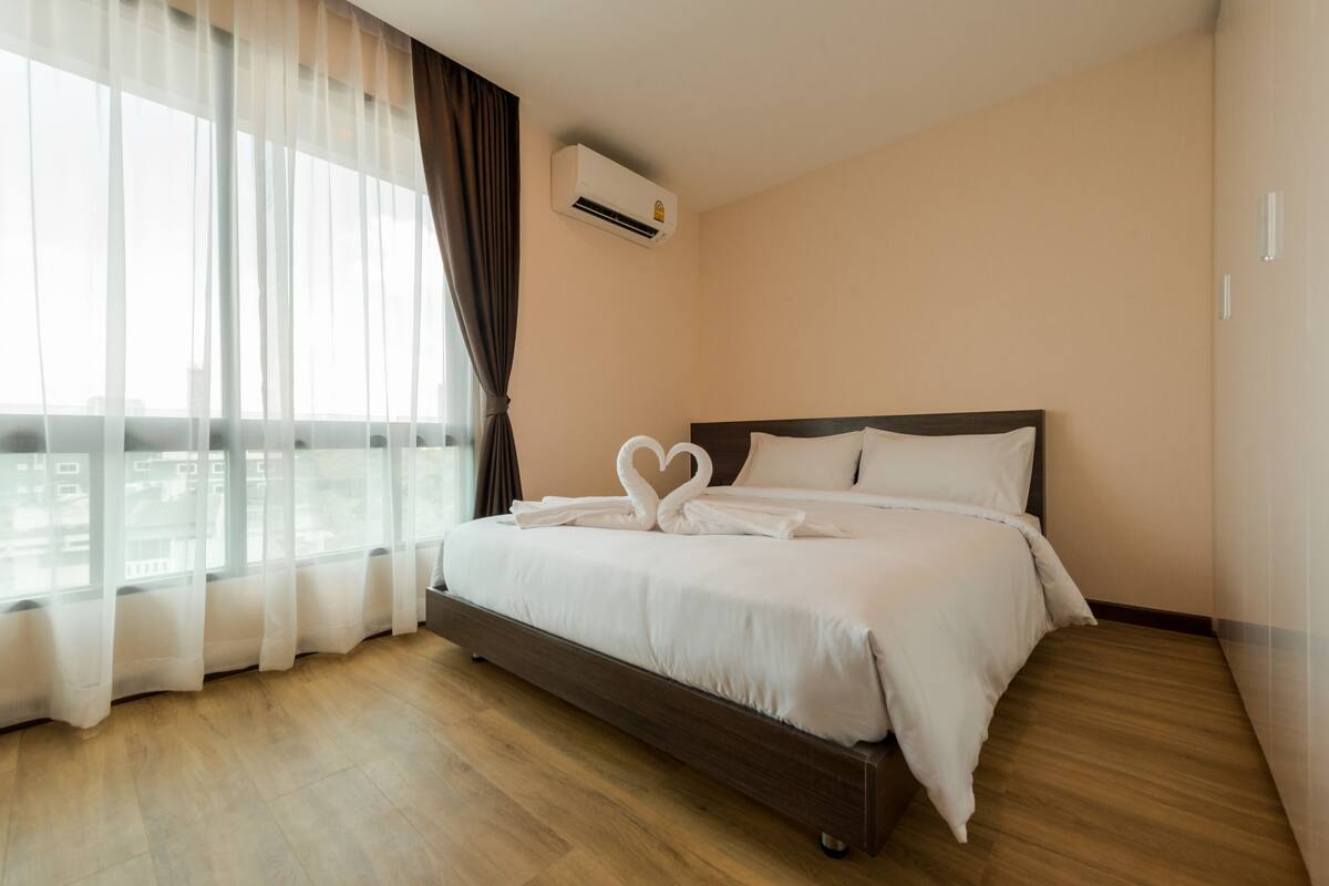 Une chambre d’hôtel avec un grand lit, une vue sur la ville et la climatisation.