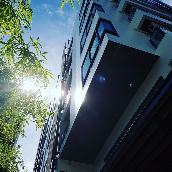 A modern building with a clear sky and sunlight. - Zensation The Residence (Bangkok)