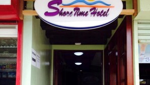 La entrada al Shore Time Hotel con un cartel sobre la puerta.