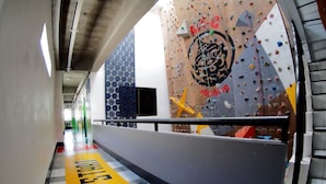 Una pared de escalada con un logotipo y la palabra 'Climbing' en un pasillo.