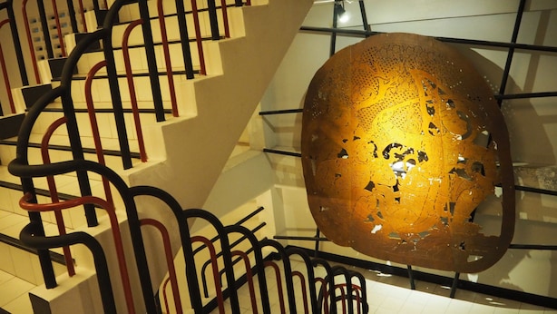 Una escalera con una escultura de vidrio singular.