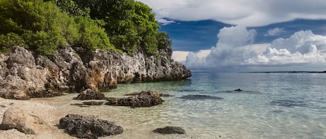 Na praia, espreguiçadeiras, guarda-sóis, toalhas de praia
