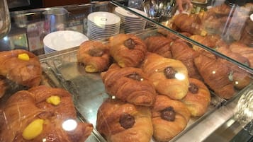 A display case with various pastries, including croissants and pastries with fillings.