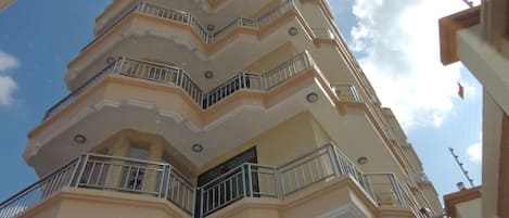 A multi-story building with balconies and a clear sky.
