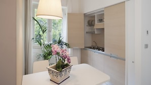 Eine moderne Küche mit weißen Schränken, einem eingebauten Backofen und einem Fenster mit Vorhängen.