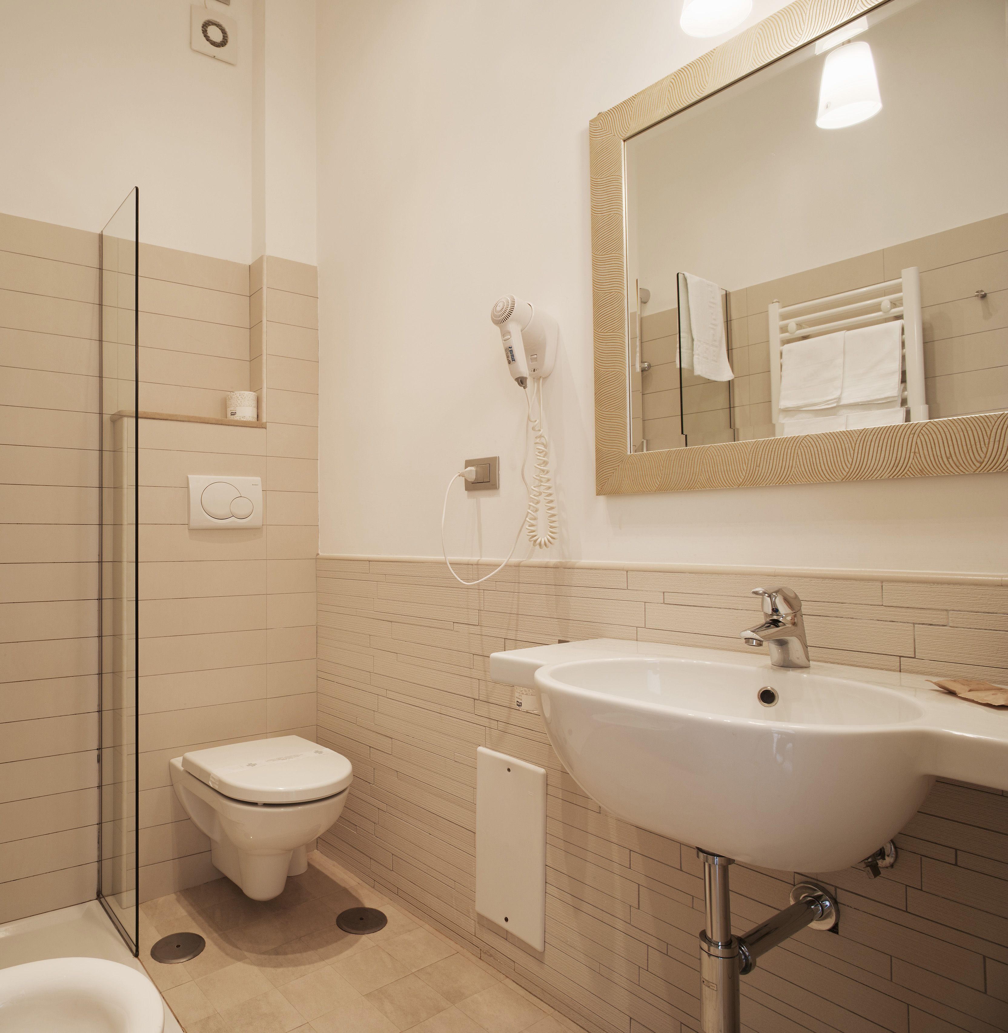 Une salle de bain avec des toilettes, un lavabo et une douche.