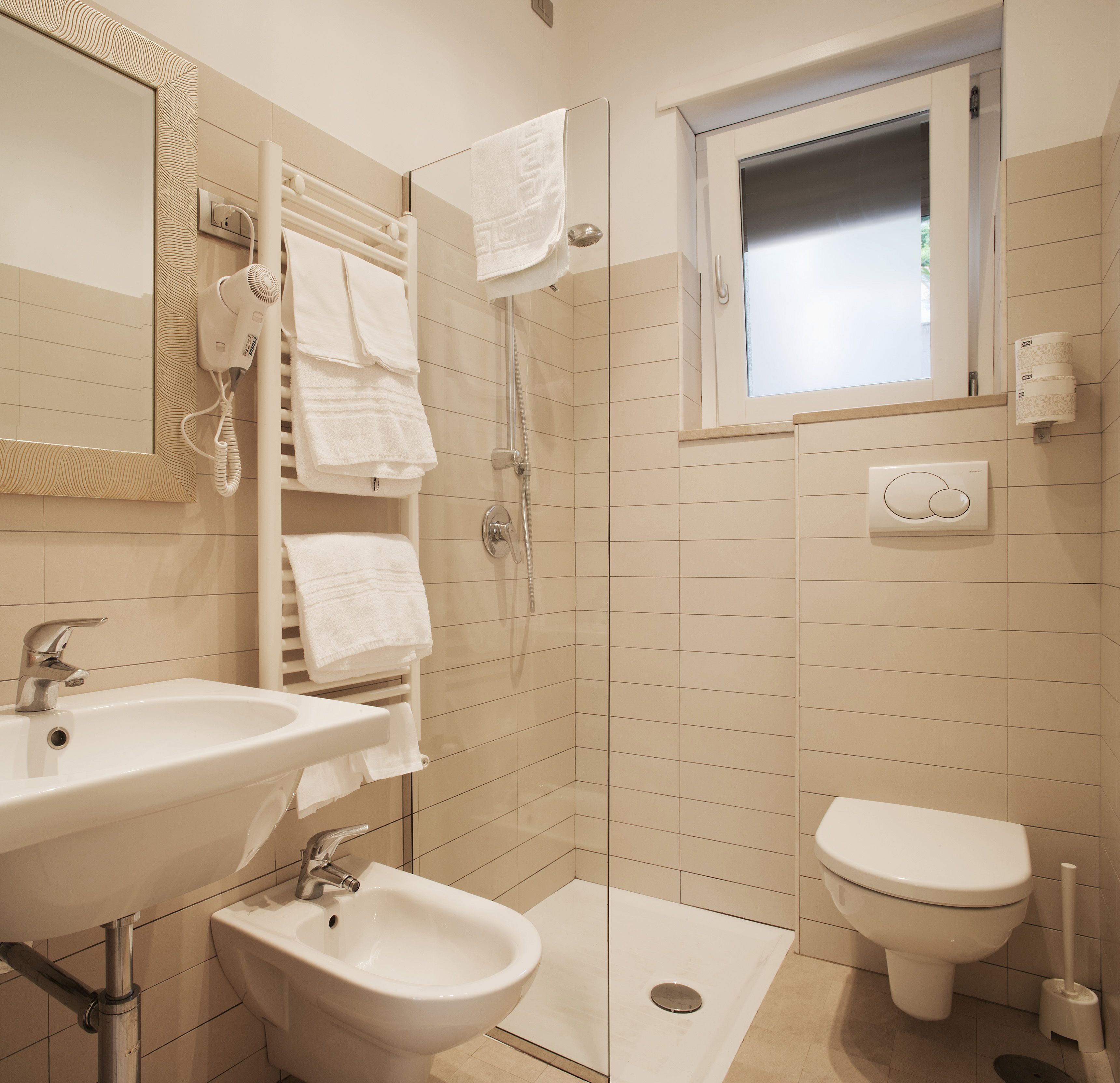 A modern bathroom with a shower, bidet, toilet, and sink.