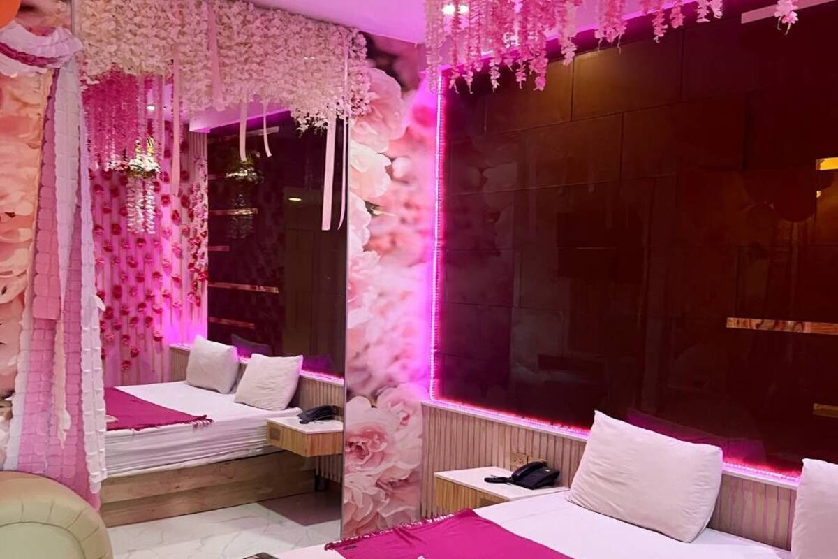A room with a bed, bedside table, and a mirror.
