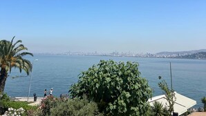 A coastal view with a clear sky, a large body of water, and a distant city skyline. - Buyukada Port Hotel (Adalar)