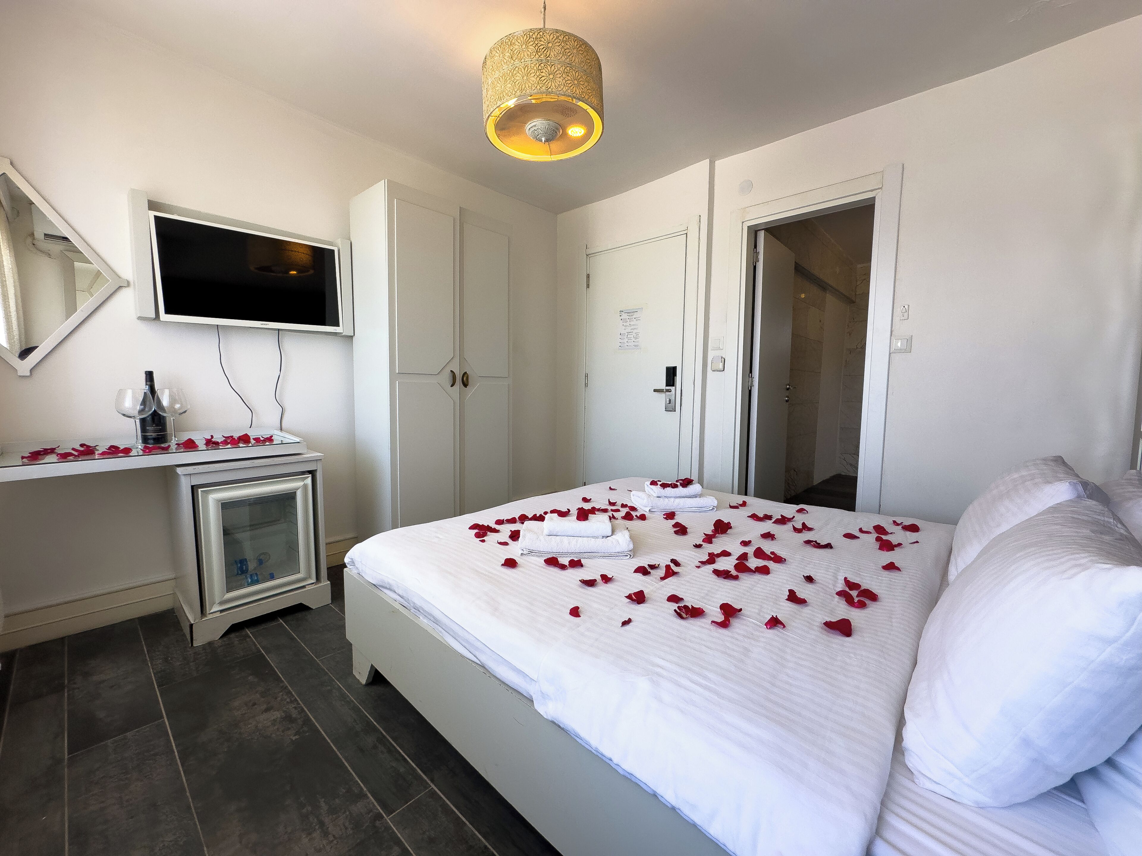 Une chambre d’hôtel équipée d’un lit, d’une télévision, d’un minibar et d’une armoire.