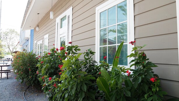 A row of windows with shutters, a covered porch, and a gravel path. - Tonrak Resort (Ongkharak)