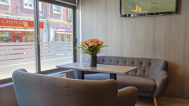 Un interior moderno con un sofá, una mesa y un jarrón de flores.