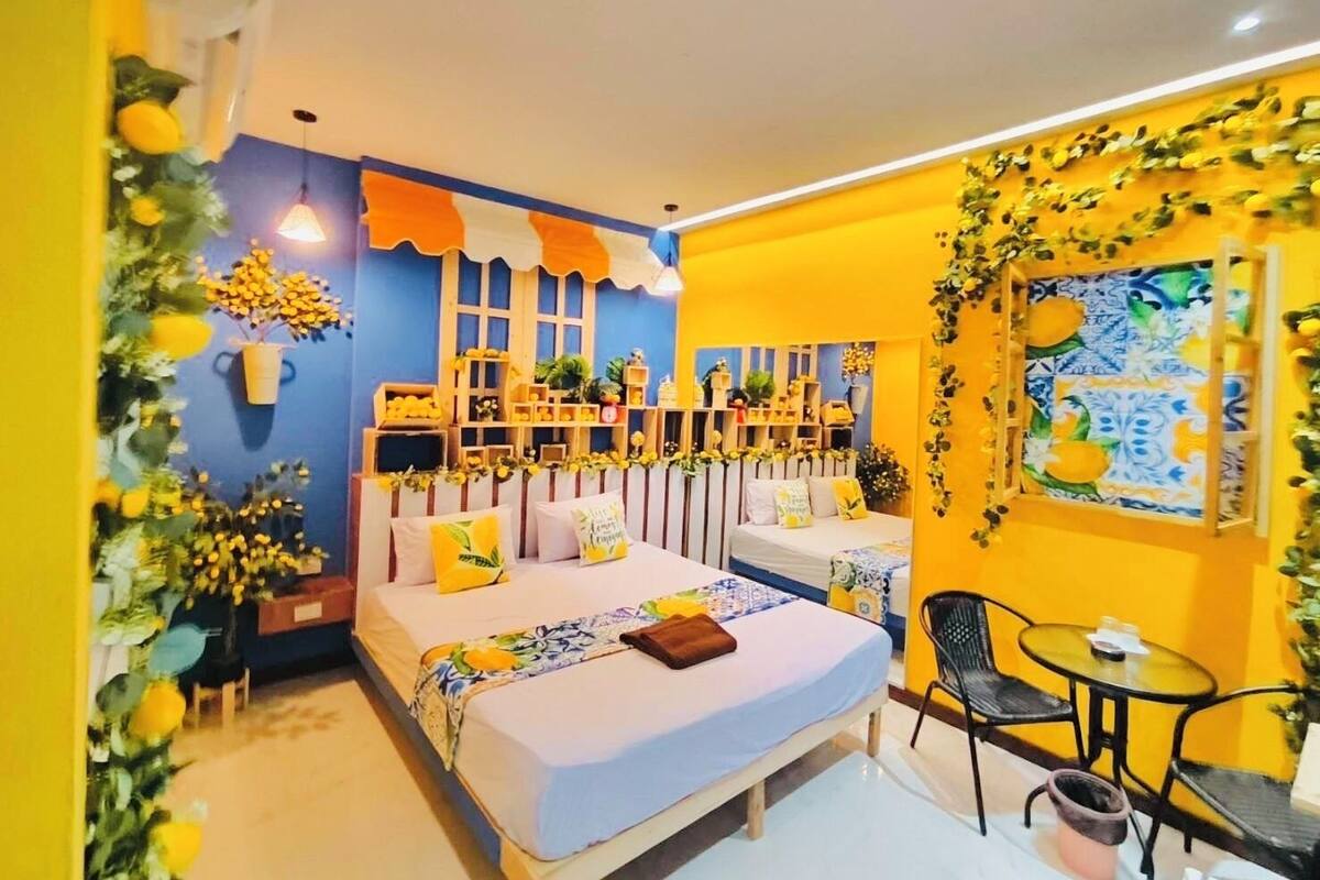 A room with a bed, bedside tables, a small table, and chairs.