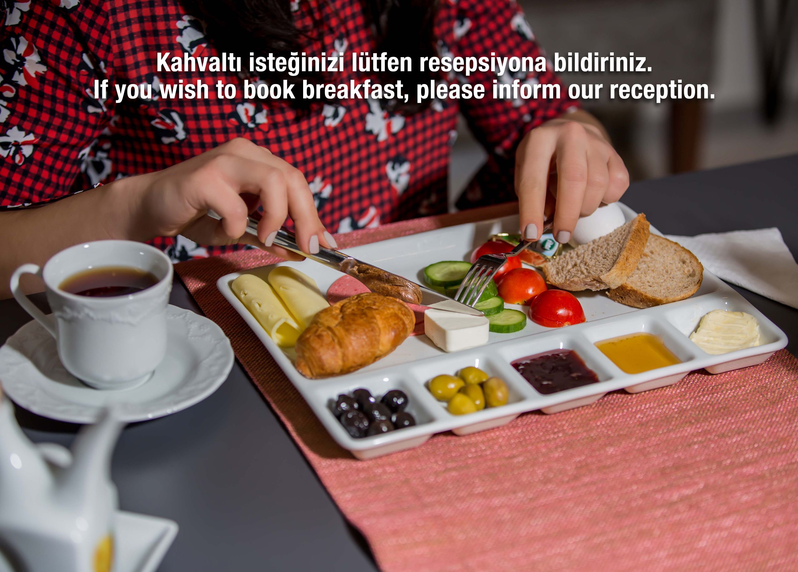 A breakfast setting with a plate of food, a cup of coffee, and a person in a red and black checkered shirt.