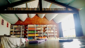 A library with bookshelves, a projector, and a brick wall. - The Soul (Wenshan)