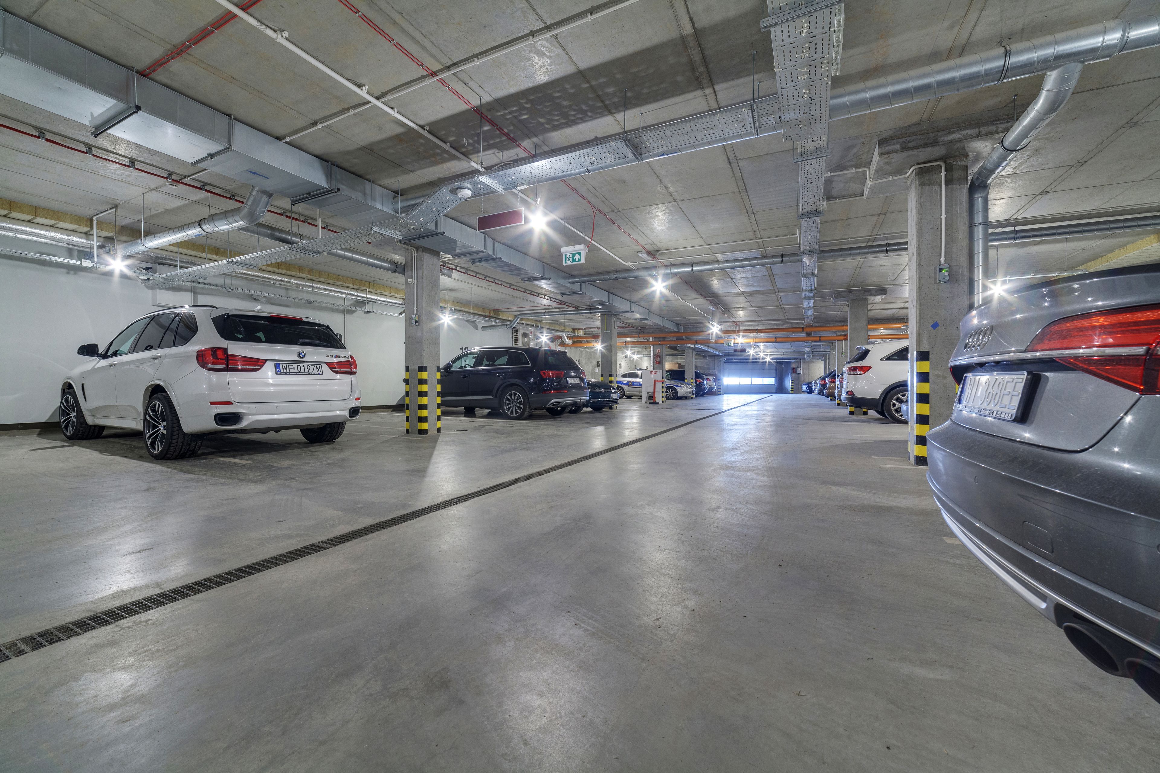 Um parque de estacionamento com vários andares e diversos carros estacionados.