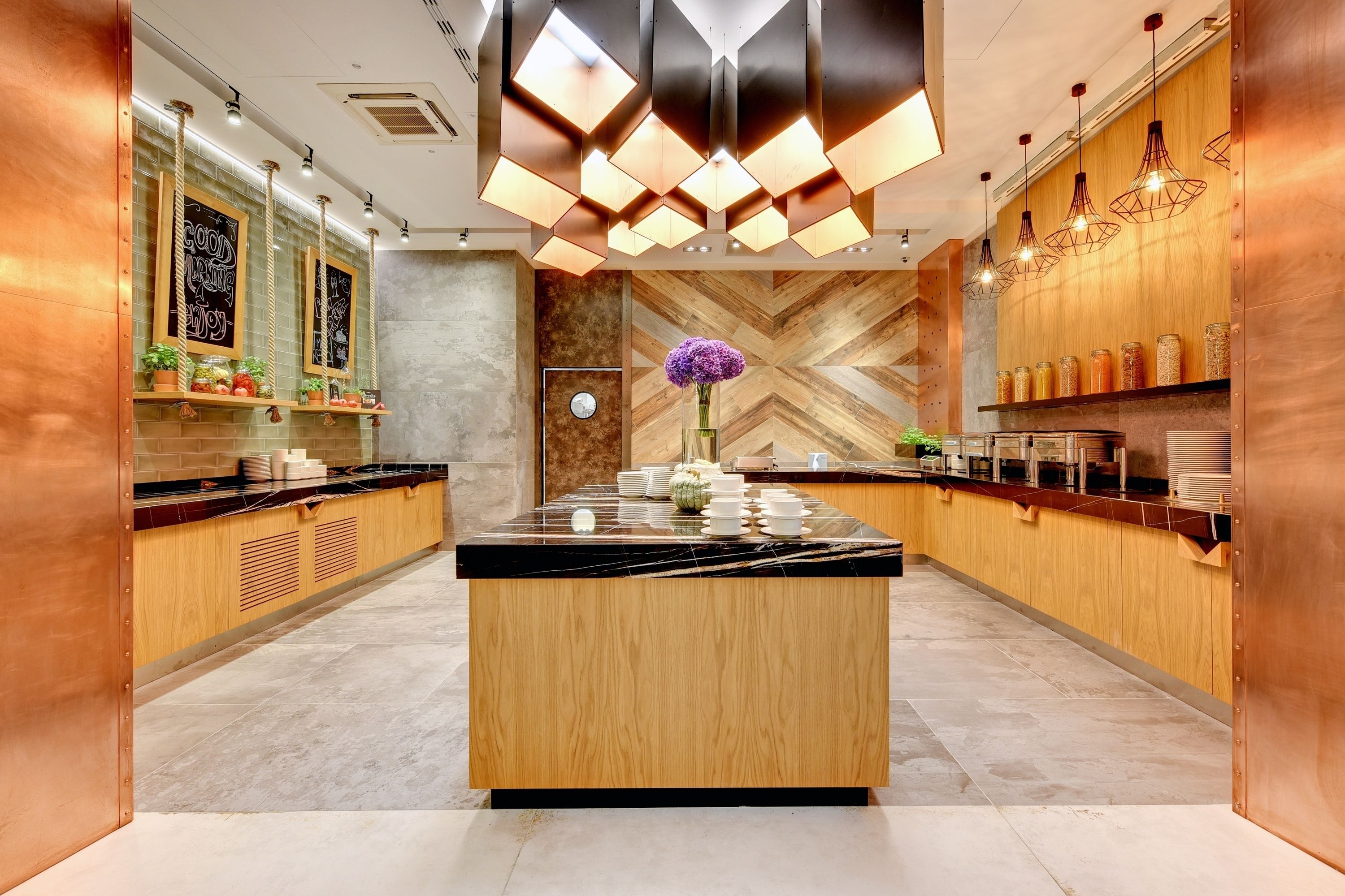 A modern kitchen with a central island, wooden cabinets, and pendant lighting.