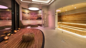 A modern spa area with a wooden bench, a glass shower enclosure, and a wall mural of a desert landscape. - Hotel Sopot (Sopot)