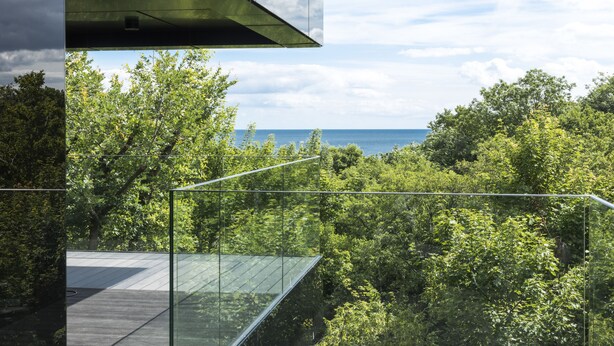 A modern glass structure with a view of a forested area and the sea. - Hotel Sopot (Sopot)