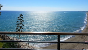 A coastal view from a balcony with a railing, overlooking a beach with people and a clear sky. - Waterfront Santa Clara Apartments (Torremolinos)