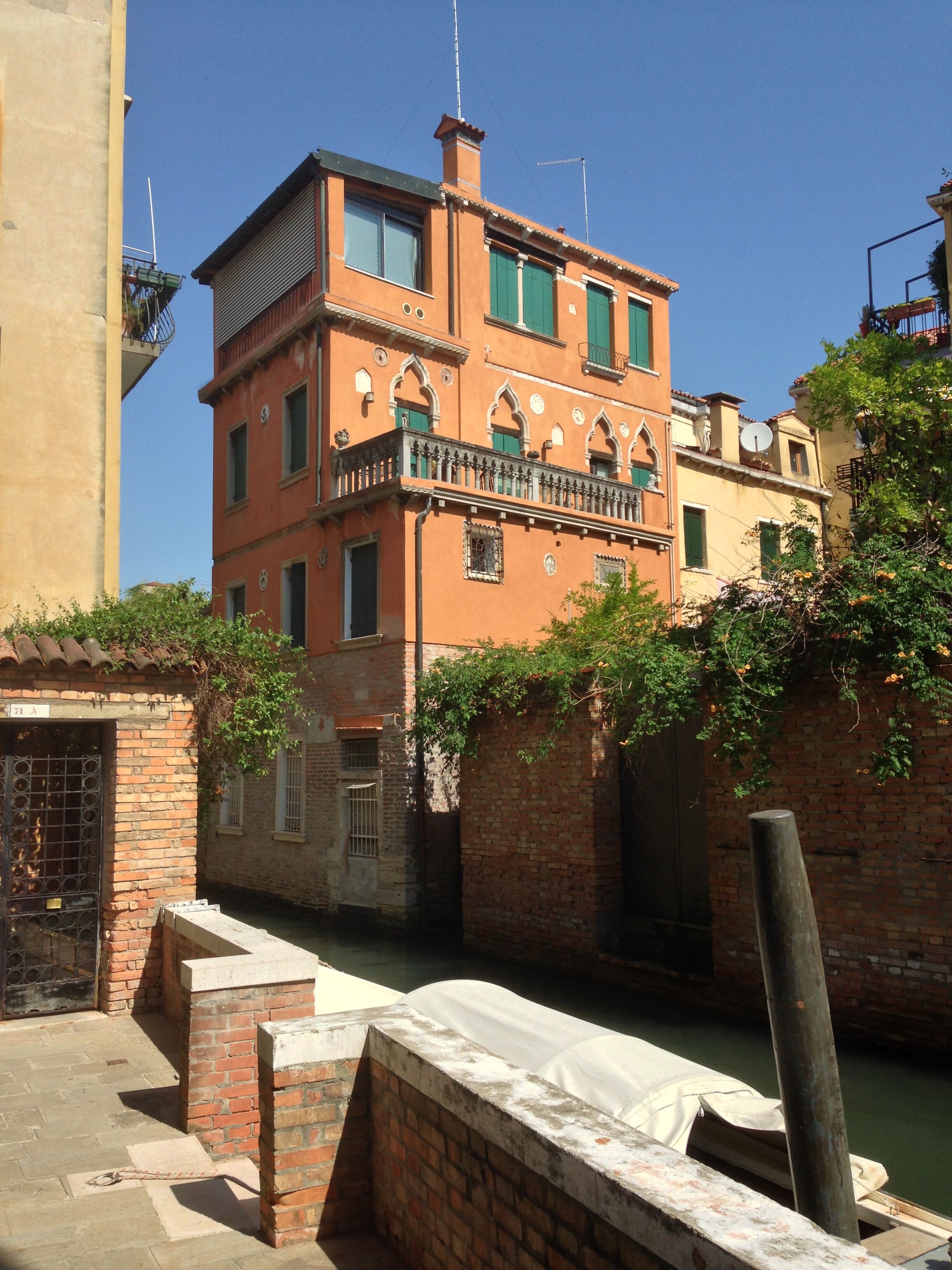 A historic building with a brick facade, arched windows, and a balcony.