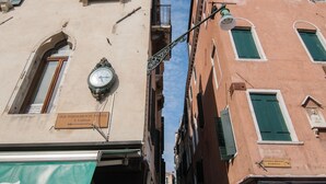 Une rue étroite bordée d’immeubles à l’architecture traditionnelle, avec notamment des fenêtres en arc de cercle et des balcons.