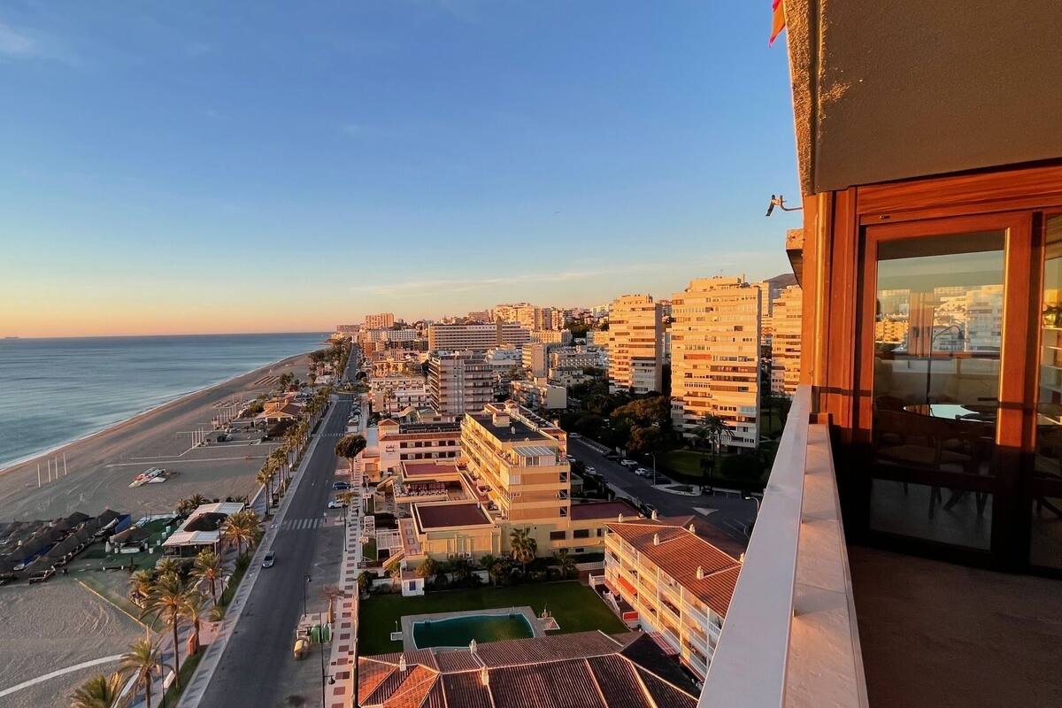 Paisatge urbà a la costa amb una platja, edificis i una carretera.