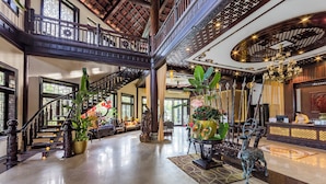 A spacious lobby with a grand staircase, a reception desk, and decorative plants. - Koi Resort and Spa Hoi An (Da Nang)