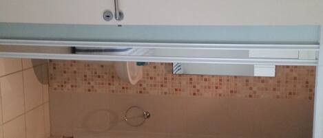 A kitchen with a tiled backsplash, a sink, and a cabinet with multiple drawers.