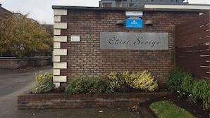 Un edificio in mattoni con un cartello che riporta la scritta "Cuirt Seoige".