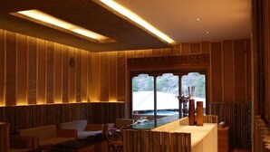Un interior moderno con paneles de madera, una zona de bar y asientos.