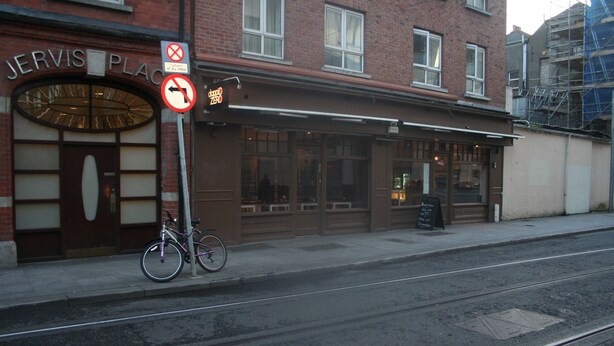 Un edificio con un cartel que dice 'Jervis Place' y una bicicleta estacionada afuera.