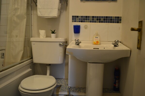 A bathroom with a toilet, sink, and shower. - Jervis Place Apartment (Dublin)
