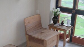 A wooden bench and a wooden table with a vase of flowers. - Dewachen Resort (Paro)
