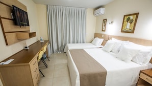 A hotel room with two beds, a desk, a chair, a TV, and an air conditioning unit. - Águas de Palmas Resort (Governador Celso Ramos)
