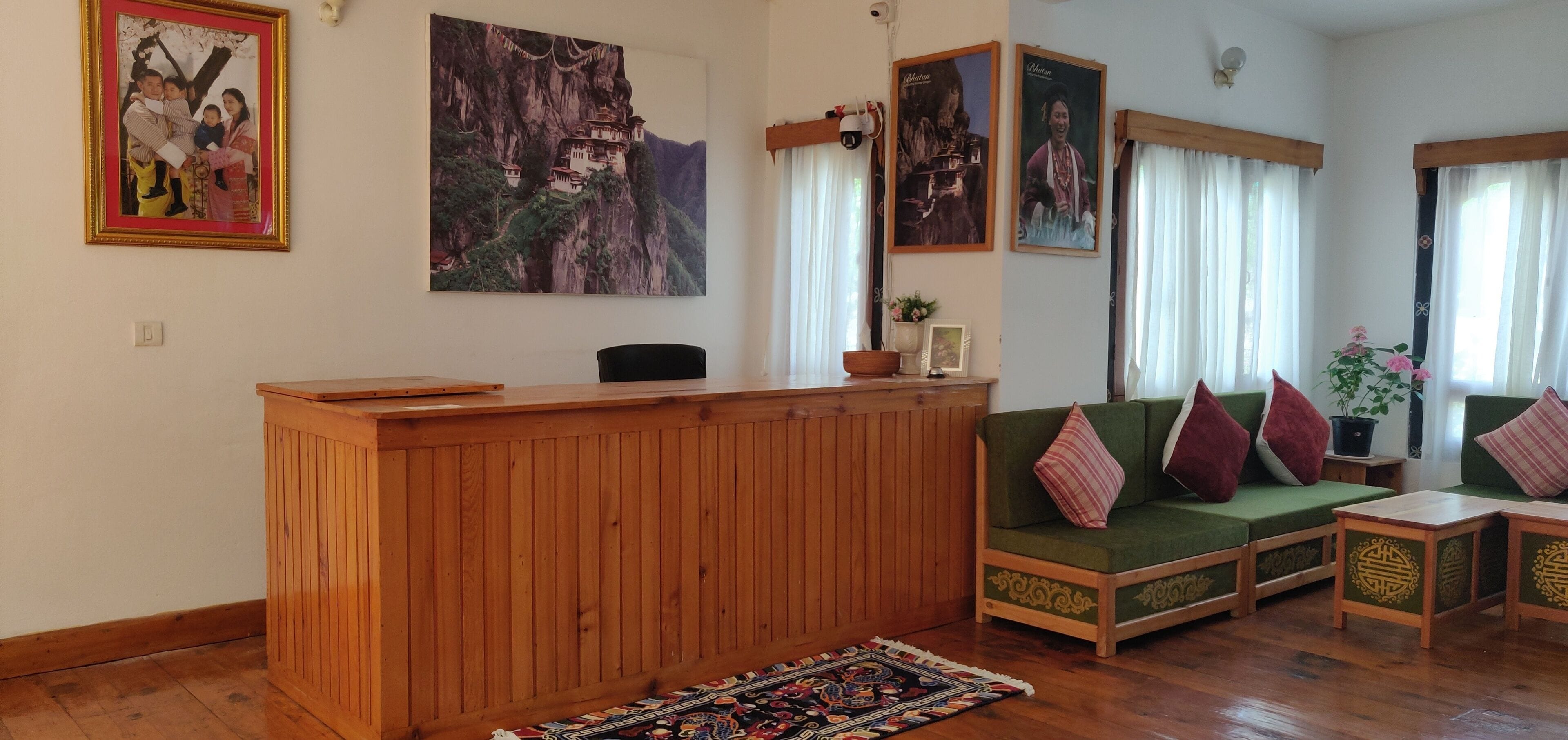 Una sala de estar con un mostrador de madera, un sofá verde y dos mesitas.