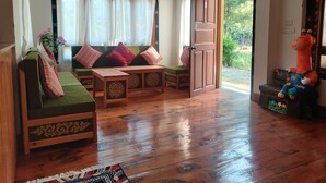 Un salon chaleureux avec un canapé vert, une table basse en bois et une statue de girafe décorative.