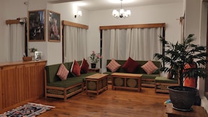 Un salon chaleureux avec des meubles en bois, un comptoir d’accueil et des coussins décoratifs.