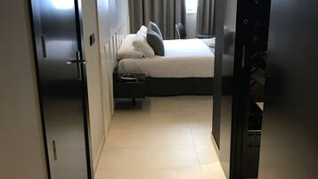 Une chambre d’hôtel moderne équipée d’un lit, d’une armoire et d’une salle de bain.