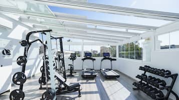 A modern gym with treadmills, weight machines, and dumbbells.