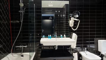 Un bagno moderno con doccia vetrata, lavandino bianco con specchio e servizi igienici.
