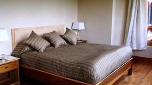 Una cama de madera con cabecera, una mesita de noche y una lámpara.
