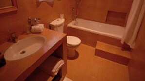 Un baño con lavamanos, inodoro y bañera.
