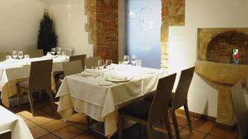 Un restaurante con mesas dispuestas para comer, una pared de ladrillo y un vitral.