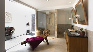 A modern bathroom with a glass shower enclosure, a wooden vanity, and a large mirror. - Villa CinCin (Canggu)
