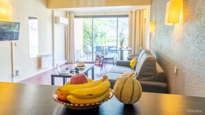 Een eettafel met een fruitschaal met bananen, een appel en een meloen.
