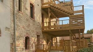 Un immeuble à plusieurs étages avec un escalier en bois menant à un balcon.