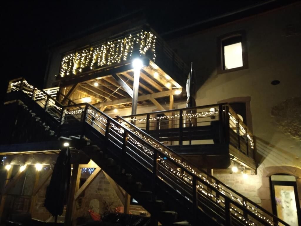 Ein mehrgeschossiges Gebäude mit beleuchteten Treppen und einem überdachten Obergeschoss.