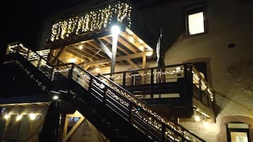 Ein mehrgeschossiges Gebäude mit beleuchteten Treppen und einem überdachten Obergeschoss.
